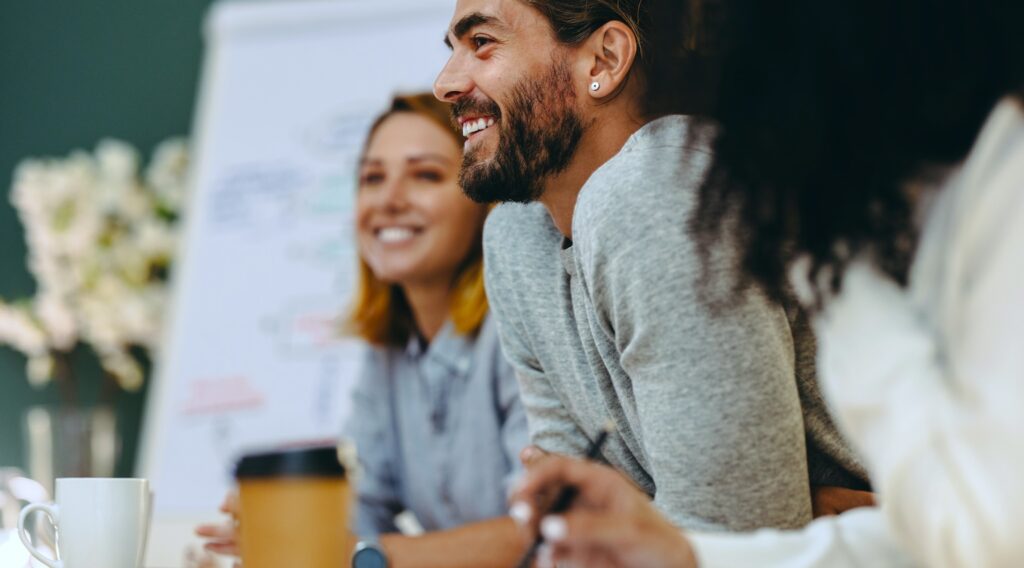 Smiling people sitting around a table in a meeting